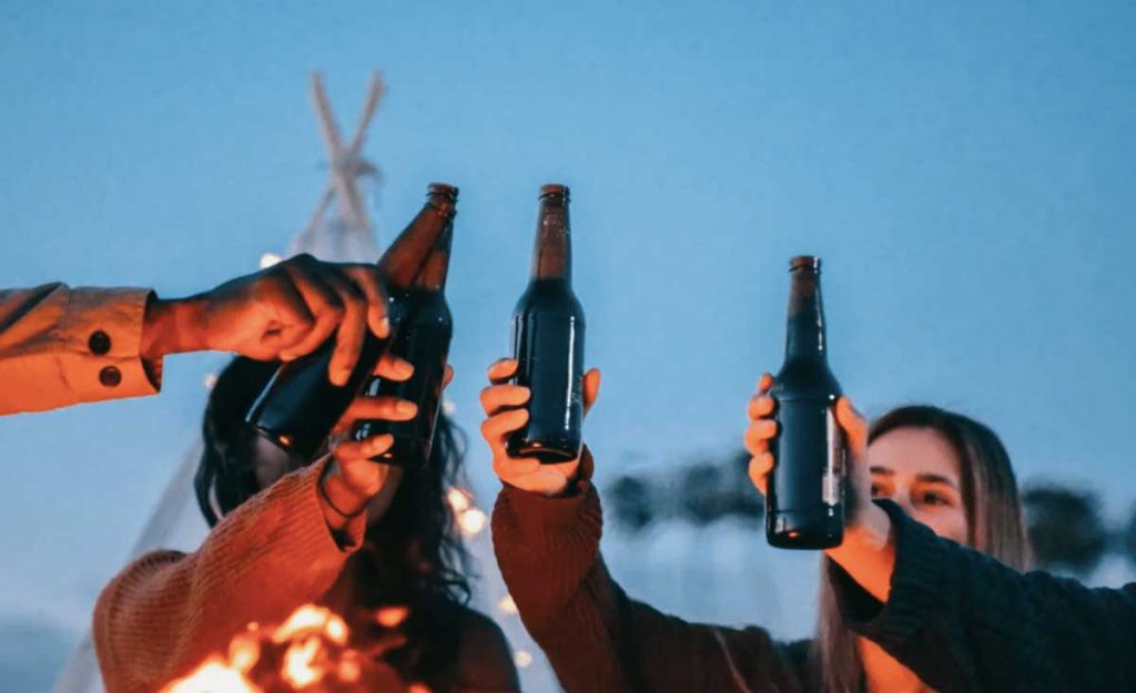 People cheering with beer bottles.